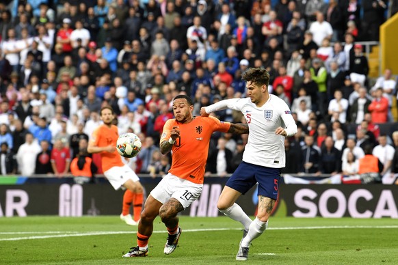 Netherlands&#039; Memphis Depay, left, fights for the ball with England&#039;s John Stones during the UEFA Nations League semifinal soccer match between Netherlands and England at the D. Afonso Henriq ...