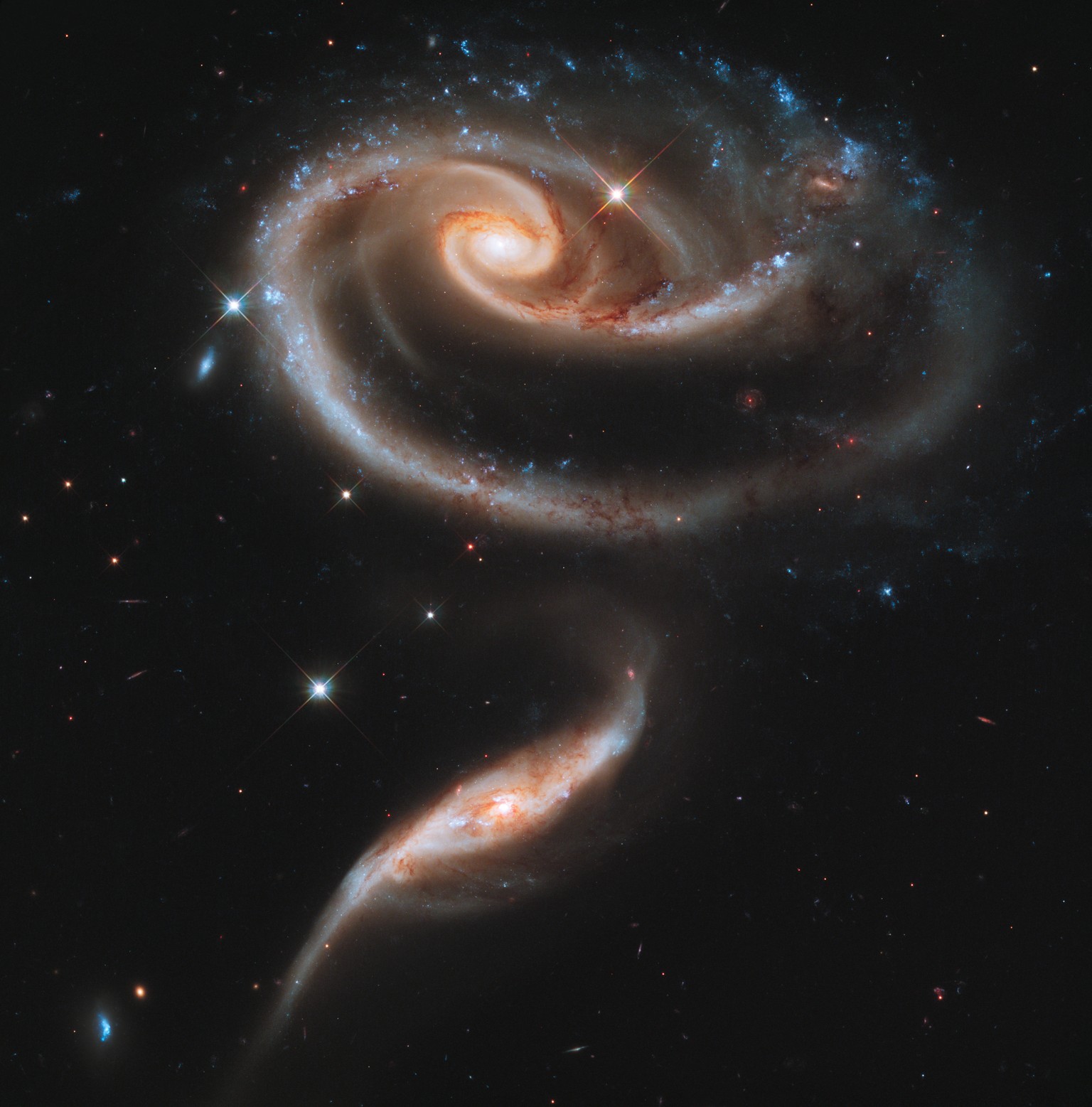 This image of a pair of interacting galaxies called Arp 273 was released to celebrate the 21st anniversary of the launch of the NASA/ESA Hubble Space Telescope. The distorted shape of the larger of th ...