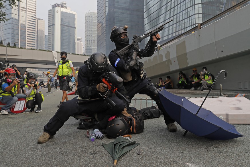 Police detain protestors during the demonstration in Hong Kong, Sunday, Sept. 29, 2019. Riot police fired tear gas Sunday after a large crowd of protesters at a Hong Kong shopping district ignored war ...
