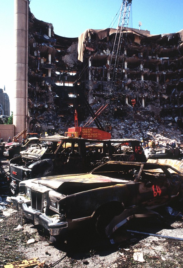 The bombed remains of automobiles with the bombed Federal Building in the background. The military is providing around the clock support since a car bomb exploded inside the building on Wednesday, Apr ...