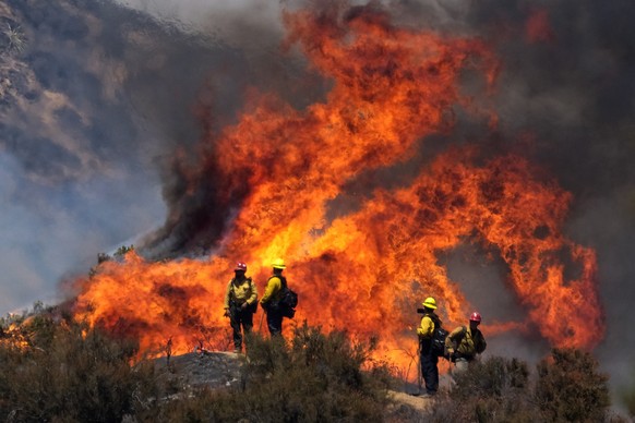 Firefighters watch the Apple Fire in Banning, Calif., Sunday, Aug. 2, 2020. (AP Photo/Ringo H.W. Chiu)