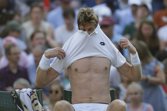 Kevin Anderson of South Africa changes his shirt in a game break during the men&#039;s singles match against Gael Monfils of France on the seventh day at the Wimbledon Tennis Championships in London,  ...