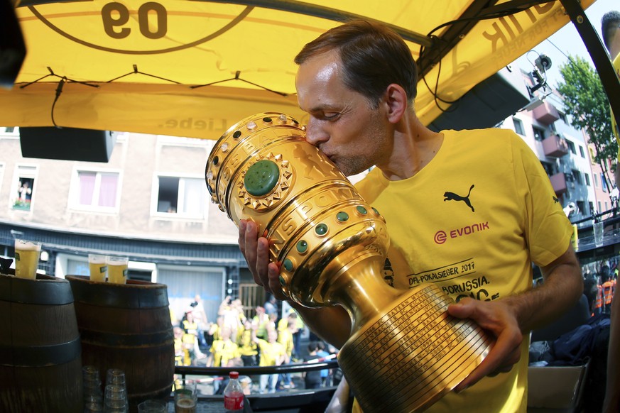 Coach Thomas Tuchel kisses the trophy as the truck with Borussia Dortmund players arrives at the Borsigplatz place in Dortmund, Germany, Sunday, May28, 2017. Borussia Dortmund won the German soccer cu ...