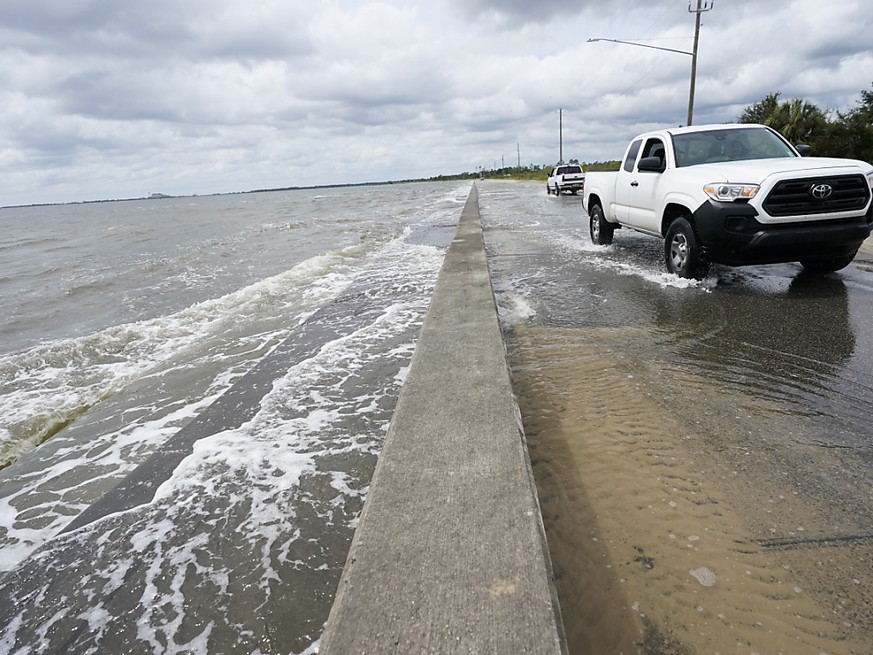 Ein Auto f�hrt �ber eine Stra�e, die durch den Tropensturm mit Meerwasser �berflutet ist. Hurrikan �Sally� hat auf seinem Weg in Richtung der US-Golfk�ste weiter an Kraft gewonnen. Foto: Gerald Herbrt ...