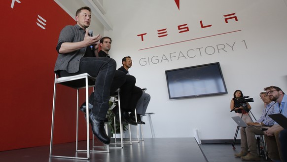 FILE - In this Tuesday, July 26, 2016, file photo, Elon Musk, CEO of Tesla Motors Inc., left, discusses the company&#039;s new Gigafactory in Sparks, Nev. On Wednesday, Aug. 3, 2016, Tesla reports fin ...