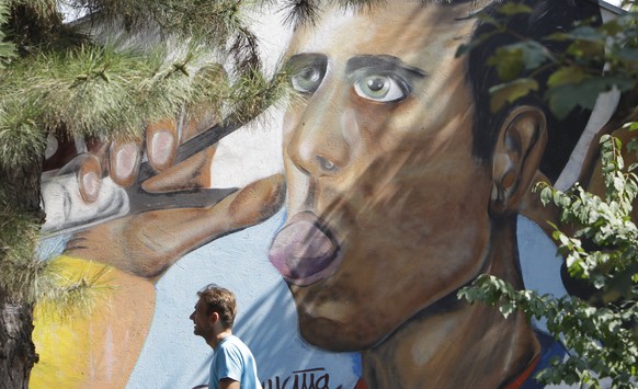 epa06960152 A man passes in front of a graffiti of tennis player Novak Djokovic in Belgrade, Serbia, 20 August 2018. Novak Djokovic became the first ever tennis player to win all nine Masters 1,000 to ...