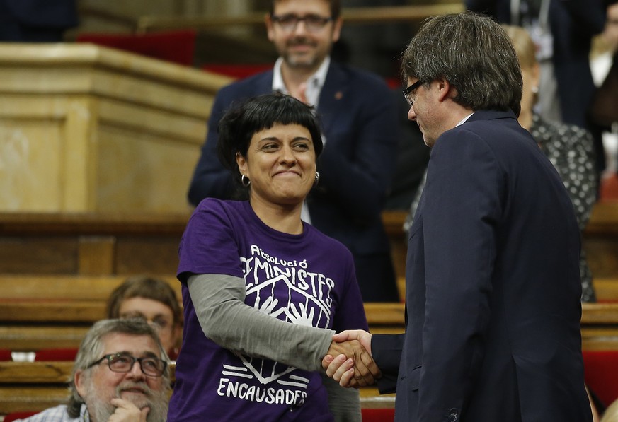 President of Catalonia Carles Puigdemont, right, shakes hands with Anna Gabriel, deputy of anti-capitalist Candidatura d&#039;Unitat Popular (CUP) party after a debate on his presidency at the Parliam ...