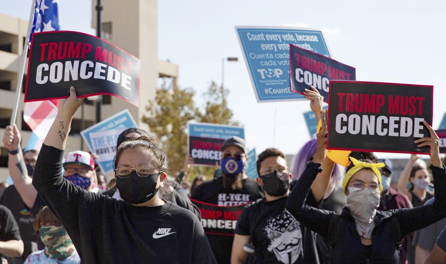 Demonstrators holding &quot;Trump must concede&quot; signs march following a &quot;Count Every Vote&quot; rally in downtown Dallas on Saturday, Nov. 7, 2020. (Juan Figueroa/The Dallas Morning News via ...