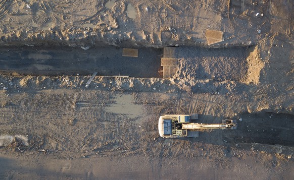 epaselect epa08355254 In an aerial photograph, a backhoe is seen next to large burial trenches and abandoned buildings on Hart Island, located in the Long Island sound, off the coast of the Bronx, New ...