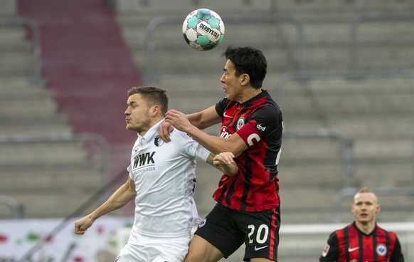 Augsburg&#039;s Alfred Finnbogason, left, and Frankfurt&#039;s Makoto Hasebe challenge for the ball during the Bundesliga soccer match between FC Augsburg and Eintracht Frankfurt in Augsburg, Germany, ...