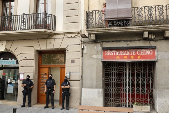 Police officers stand outside a building during a search in Ripoll, north of Barcelona, Spain, Friday, Aug. 18, 2017. Police on Friday shot and killed five people carrying bomb belts who were connecte ...
