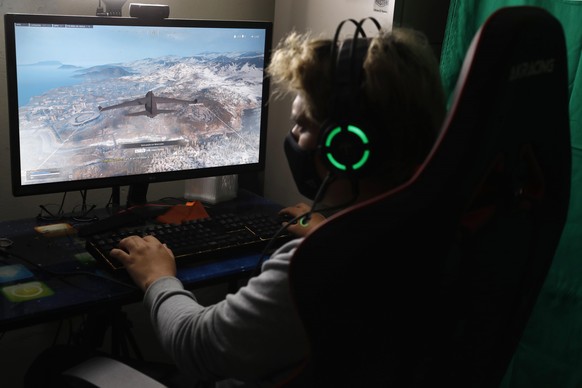 epa08724274 Mikhail Huacan plays Call of Duty Warzone online with other Latin American players, from his home in Lima, Peru, 04 October 2020 (issued 06 October). 2020 has undoubtedly been a bad year f ...