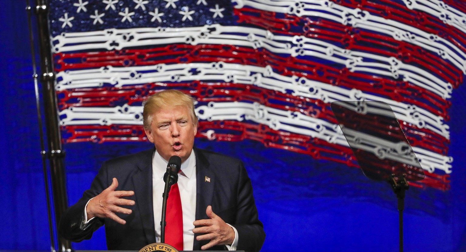 epa05914048 US President Donald J. Trump gestures a he speaks in front of an American flag made of tools at the Snap-on Tools headquarters in Kenosha, Wisconsin, USA, 18 April 2017. Trump spoke on his ...