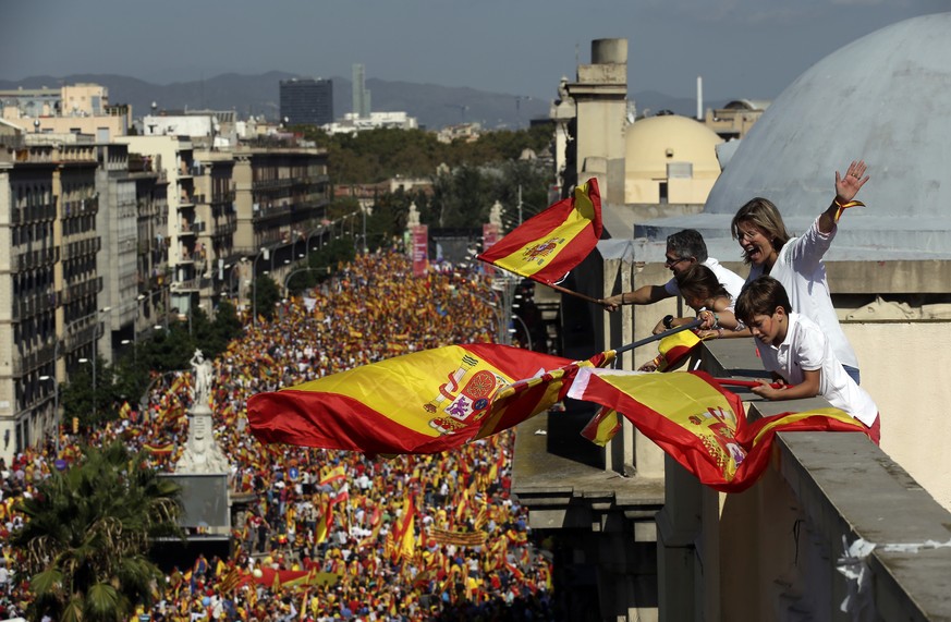 People on a rooftop wave Spanish flags during a march in downtown Barcelona, Spain, to protest the Catalan government&#039;s push for secession from the rest of Spain, Sunday Oct. 8, 2017. Sunday&#039 ...