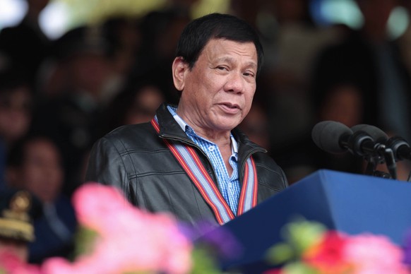 epa05801463 A handout photo made available dated and released on 18 February 2017 by the Presidential Photographers Division (PPD) shows Filipino President Rodrigo Duterte (C) speaking during the Phil ...