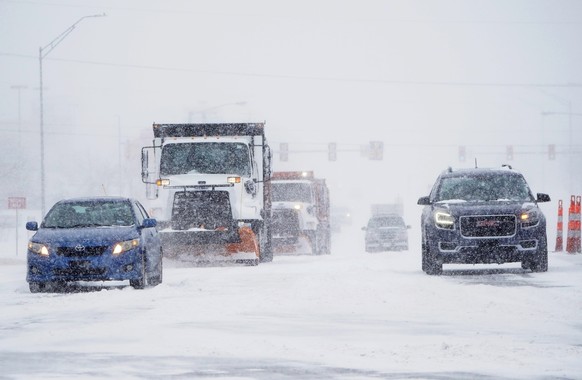Cars and plows are driven during a winter storm Sunday, Feb. 14, 2021, in Oklahoma City. Snow and ice blanketed large swaths of the U.S. on Sunday, prompting canceled flights, making driving perilous  ...
