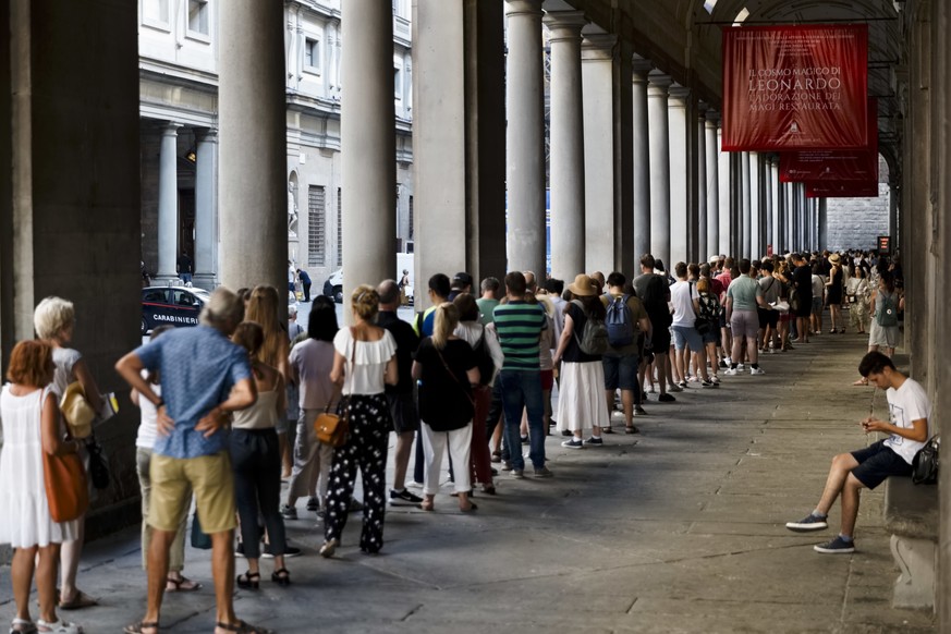 People line up to enter in the Uffizi Gallery in Florence, Italy, Tuesday, Aug. 1, 2017. The famed Uffizi Gallery in Florence is taking a swipe at so-called &quot;hit-and-run tourism,&quot; announcing ...