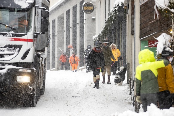Menschen sind bei starkem Schneefall unterwegs in St. Moritz am Samstag, 5. Dezember 2020. (KEYSTONE/Alexandra Wey)..
