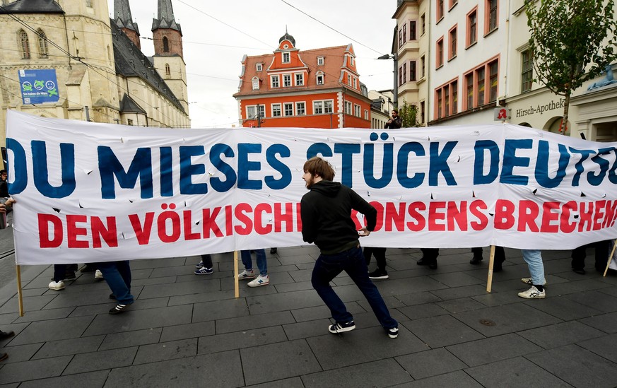 epa07913171 Protesters hold a banner reading &#039;You lousy piece of germany - break nationalist consensus&#039; during a rally against anti-Semitism and xenophobia in Halle an der Saale, Germany, 11 ...