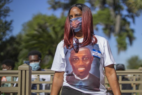 epa08410425 Tasha McQueen wears a custom Ahmaud Arbery face mask and t-shirt she had made while participating in a protest after the shooting death of unarmed black jogger Ahmaud Arbery outside the Gl ...