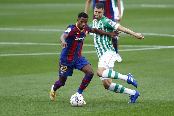 Barcelona&#039;s Ansu Fati, left, fights for the ball with Betis&#039; Guido Rodriguez during the Spanish La Liga soccer match between FC Barcelona and Betis at the Camp Nou stadium in Barcelona, Spai ...