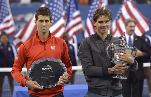 epa03860249 Rafael Nadal of Spain (R) poses with the championship trophy after defeating Novak Djokovic of Serbia (L) who holds the runner up trophy after the men&#039;s final on the fifteenth day of  ...