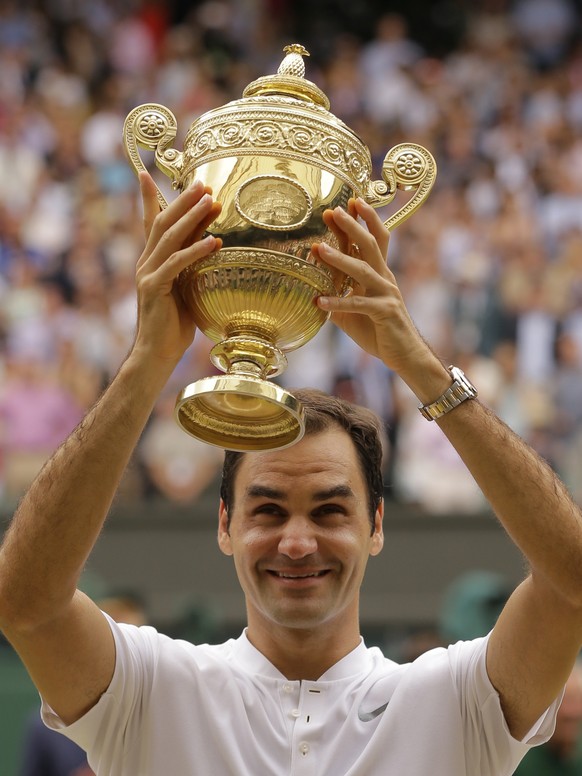 Switzerland&#039;s Roger Federer holds the trophy after defeating Croatia&#039;s Marin Cilic to win the Men&#039;s Singles final match on day thirteen at the Wimbledon Tennis Championships in London S ...