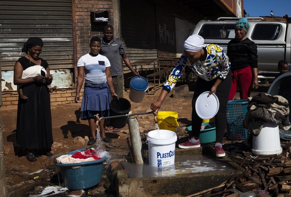 epa08364120 Women use a communal water point to wash their clothes and collect water in the Alexandra township during a national lockdown following President Cyril Ramaphosa&#039;s declaration of a Na ...