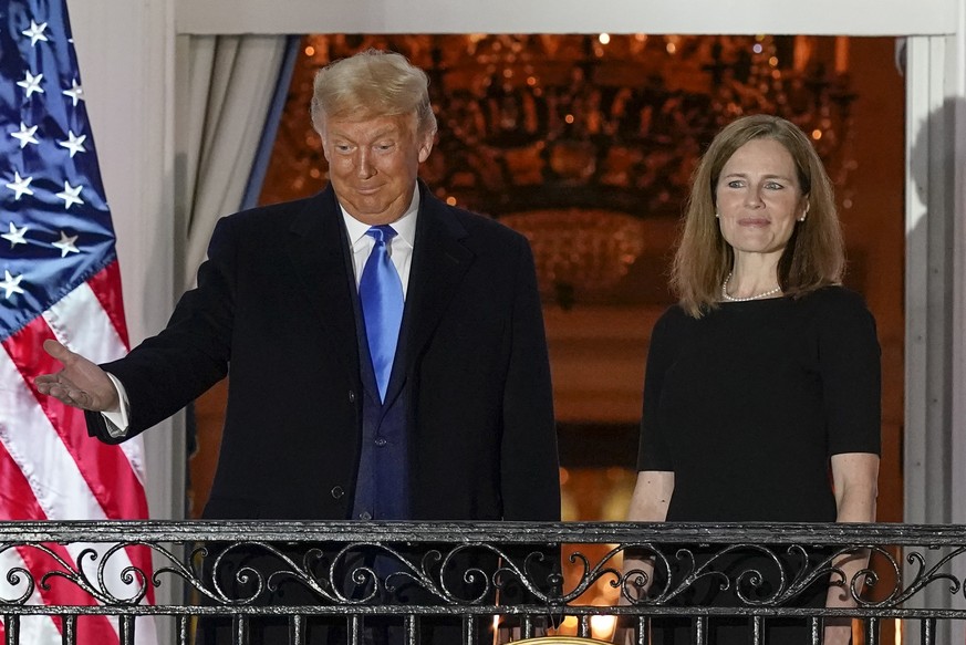 President Donald Trump and Amy Coney Barrett stand on the Blue Room Balcony after Supreme Court Justice Clarence Thomas administered the Constitutional Oath to her on the South Lawn of the White House ...