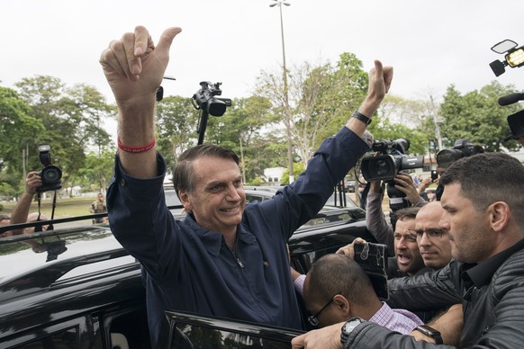 Presidential frontrunner Jair Bolsonaro, of the Social Liberal Party, flashes thumbs up to supporters after voting at a polling station in Rio de Janeiro, Brazil, Sunday, Oct. 7, 2018. Brazilians choo ...