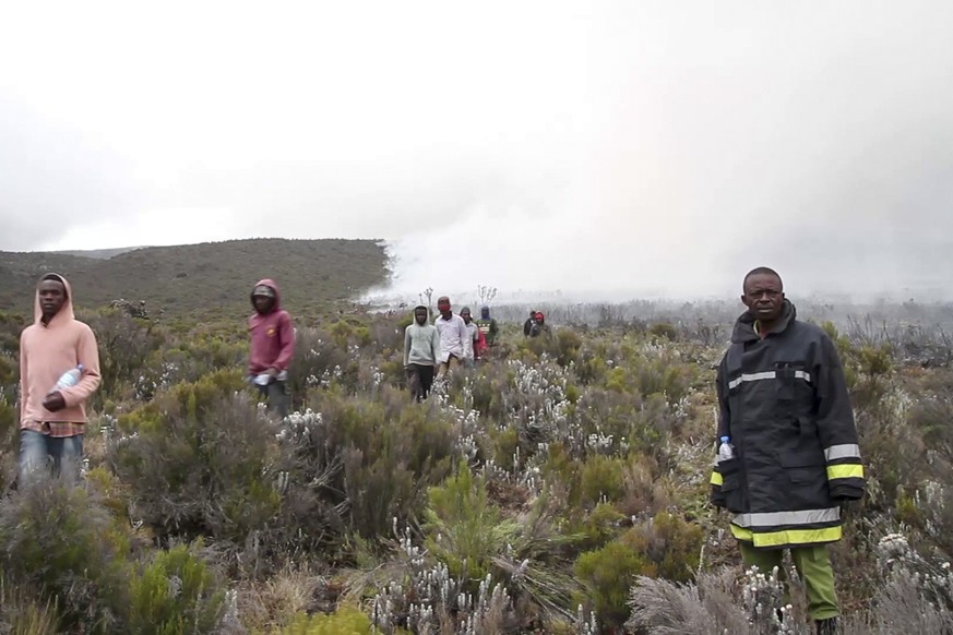 In this image made from video, rangers and volunteers help to put out fires on Mount Kilimanjaro in Tanzania on Monday, Oct. 12, 2020. Tanzanian authorities say 500 volunteers have been trying to put  ...