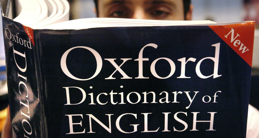 FILE - In this March 14, 2007 file photo, a man reads a copy of the Oxford Dictionary of English. Oxford Dictionaries is recognizing the power of the millennial generation with its 2017 word of the ye ...
