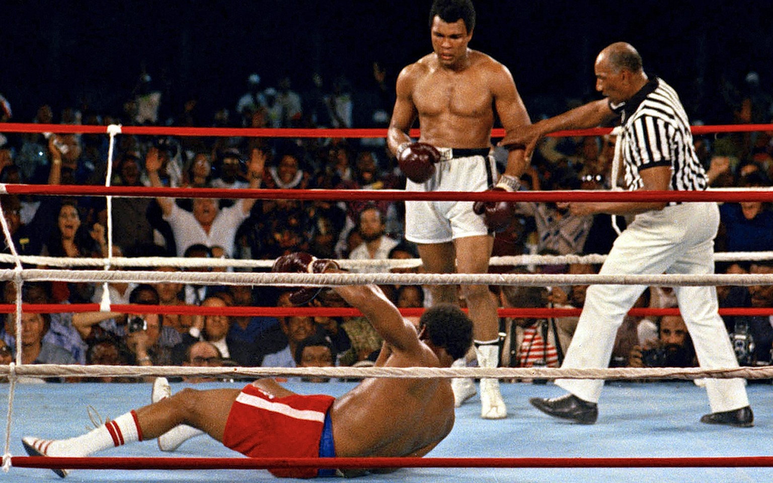 In this Oct. 30, 1974 photo, referee Zack Clayton, right, steps in after challenger Muhammad Ali looks on after knocking down defending heavyweight champion George Foreman in the eighth round of their ...