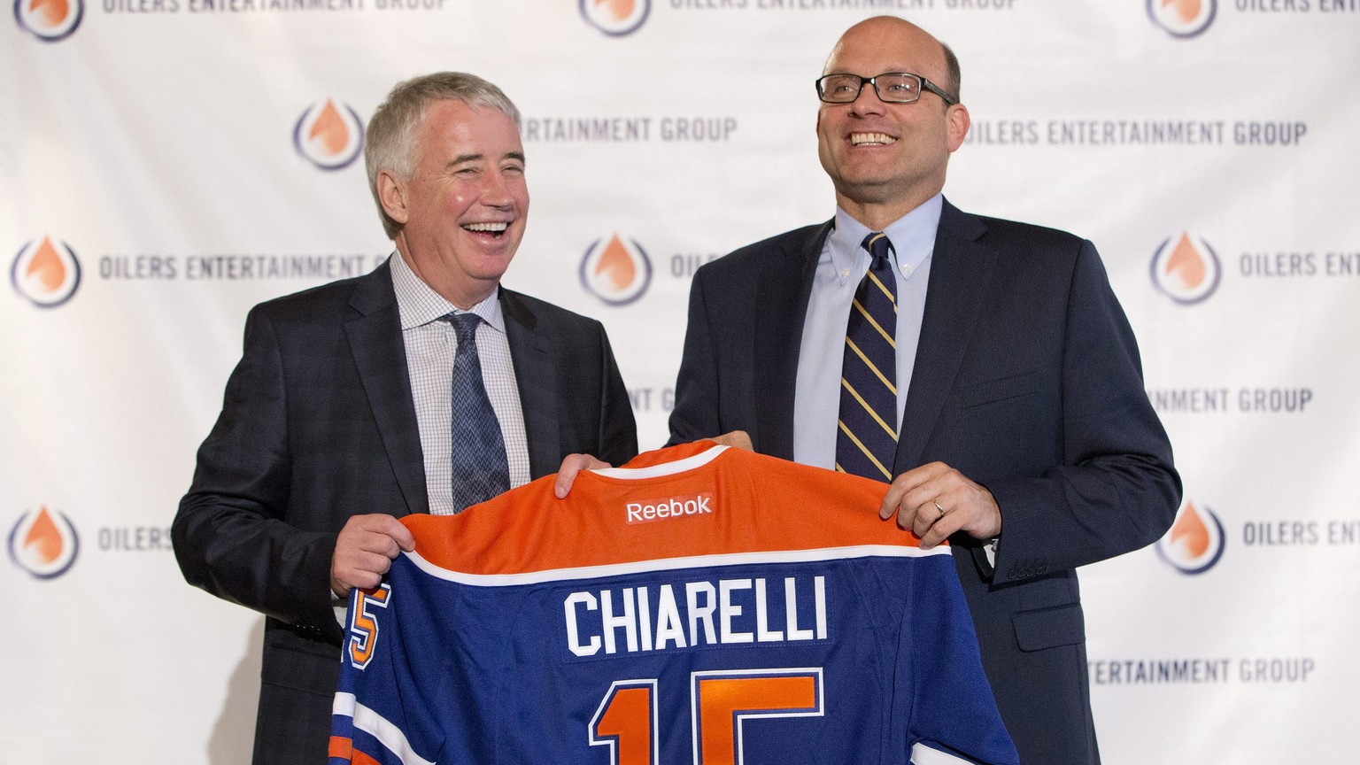 Edmonton Oilers CEO Bob Nicholson, left, and new President and General Manager Peter Chiarelli hold up an Oilers jersey with Chiarelli&#039;s name on it during an NHL hockey press conference in Edmont ...