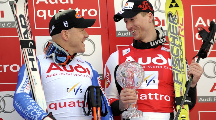 Hannes Reichelt, of Austria, right, looks at Didier Cuche, of Switzerland, as he holds the men&#039;s super-G title trophy, at the alpine ski, World Cup finals, in Bormio, Italy, Thursday, March 13, 2 ...