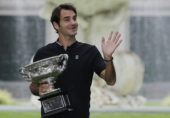 Switzerland&#039;s Roger Federer waves to fans as he holds his Australian Open trophy at Carlton Gardens in Melbourne, Australia, Monday, Jan. 30, 2017. Federer defeated Spain&#039;s Rafael Nadal in t ...