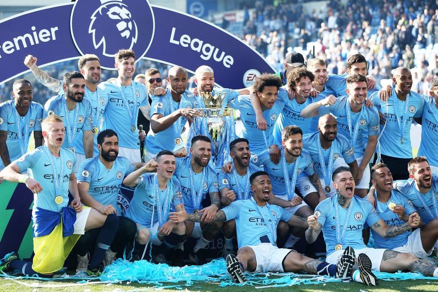 epa07565161 Manchester City captain Vincent Kompany holds the trophy as the team celebrate after the English Premier League match between Brighton and Hove Albion and Manchester City, Brighton, Britai ...