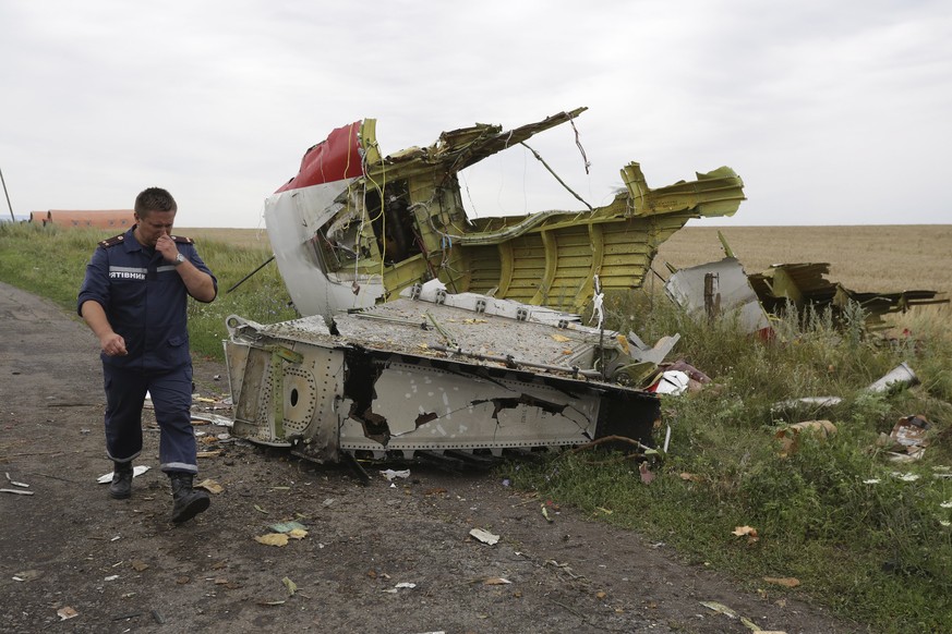 epa07657888 (FILE) - A Ukrainian rescue worker passes wreckage of the Boeing 777, Malaysia Arilines flight MH17, which crashed during flying over the eastern Ukraine region near Donetsk, Ukraine, 18 J ...