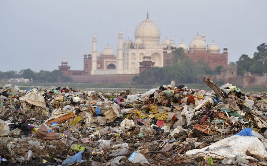 In this Friday, May 11, 2018 photo, garbage covers the area by the Yamuna river near the Taj Mahal in Agra, India. Built by Mogul Emperor Shah Jahan for his favorite wife in the north Indian city of A ...