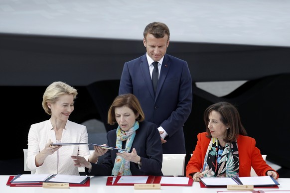 French President Emmanuel Macron, watches German Defense Minister Ursula von der Leyen, left, French Defense Minister Florence Parly and Spanish Defense Minister Margarita Robles, right, during a sign ...