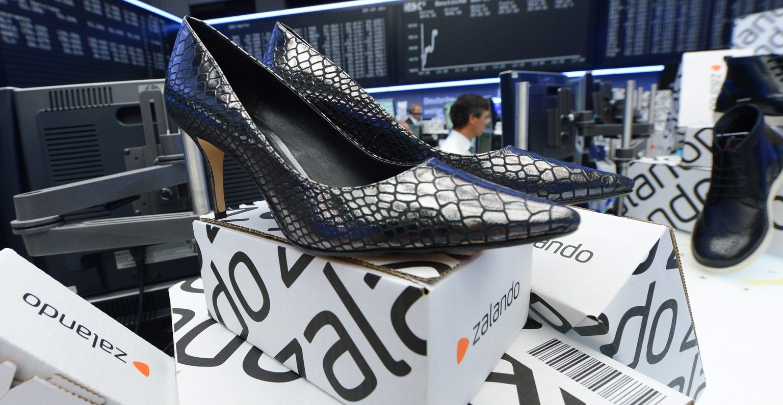 epa04425784 Zalando boxes and shoes stand in front of the German stock index DAX display panel at the Frankfurt stock exchange during the stock market launch of the online retailer company, in Frankfu ...