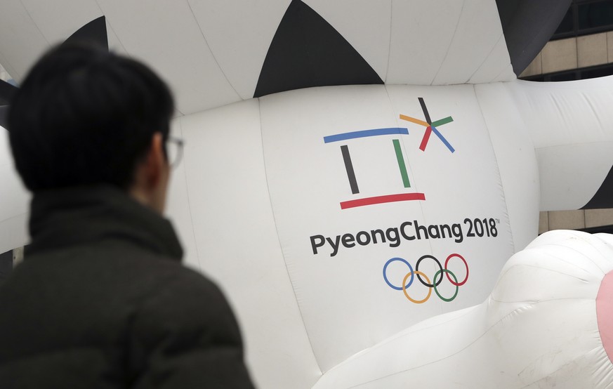 In this Dec. 29, 2017, photo, a man walks by the official emblem of the 2018 Pyeongchang Olympic Winter Games, in downtown Seoul, South Korea. North Korean leader Kim Jong Un said Monday the United St ...