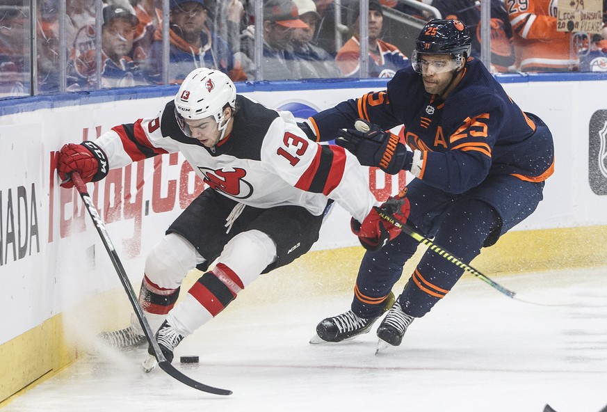 New Jersey Devils&#039; Nico Hischier (13) and Edmonton Oilers&#039; Darnell Nurse (25) race to the puck during the first period of an NHL hockey game Friday, Nov. 8, 2019, in Edmonton, Alberta. (Jaso ...