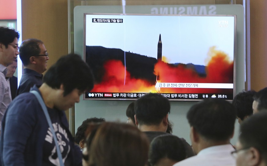 People watch a TV news program showing a file image of a missile launch by North Korea, at the Seoul Railway Station in Seoul, South Korea, Sunday, May 21, 2017. North Korea on Sunday fired a midrange ...