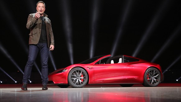 epa06335606 A handout photo made available by Tesla 16 November 2017, showing Tesla founder Elon Musk presenting the new Roadster electric sports vehicle (on background), presented to media 16 Novembe ...