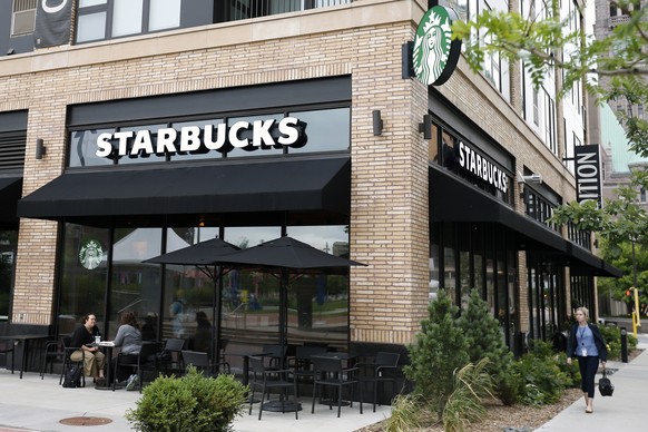 FILE - In this July 10, 2019 file, photo customers visit at a Starbucks in Minneapolis. Starbucks is adding plant-based meat to its U.S. menu for the first time. The Seattle-based coffee chain says a  ...