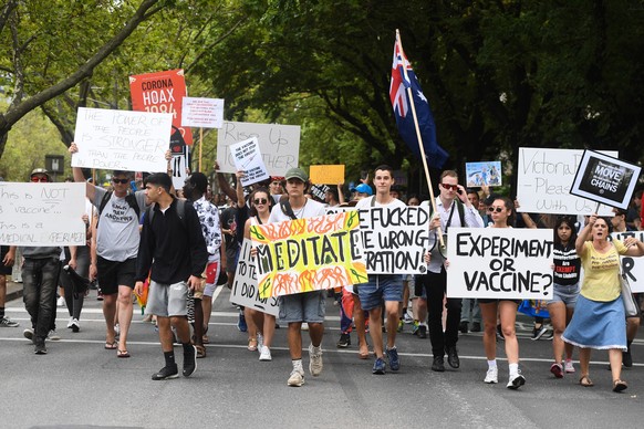 epa09025121 Protesters march and hold placards during an anti-vaccination rally in Melbourne, Australia, 20 February 2021. The national rollout of the Pfizer vaccine will begin on Monday in what will  ...