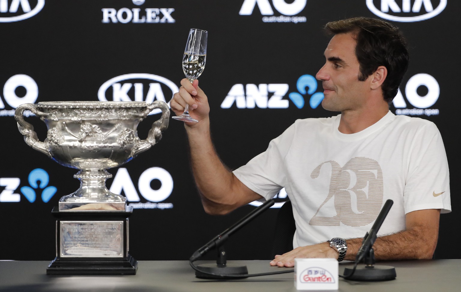 Switzerland&#039;s Roger Federer gestures with his glass of champagne at a press conference after defeating Croatia&#039;s Marin Cilic in the men&#039;s singles final at the Australian Open tennis cha ...