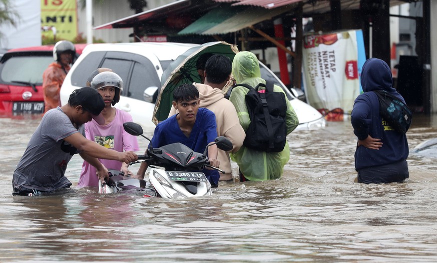 Indonesian people wade through floodwaters at Jatibening on the outskirt of Jakarta, Indonesia, Wednesday, Jan. 1, 2020. Severe flooding hit Indonesia&#039;s capital just after residents celebrating N ...