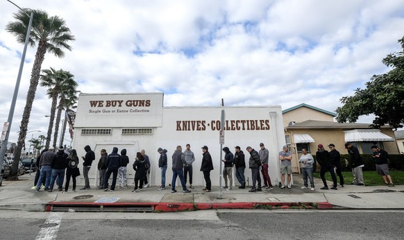 People wait in a line to enter a gun store in Culver City, Calif., Sunday, March 15, 2020. Coronavirus concerns have led to consumer panic buying of grocery staples, and now gun stores are seeing a si ...